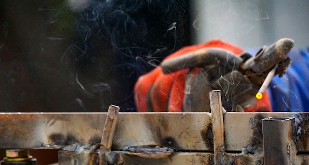 welder is welding metal part on a construction site