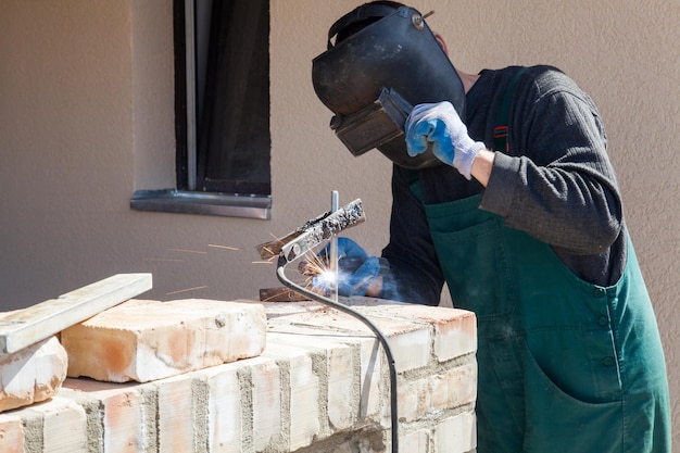 Photo welder welds on the building site