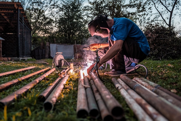 The welder welds the iron pipes