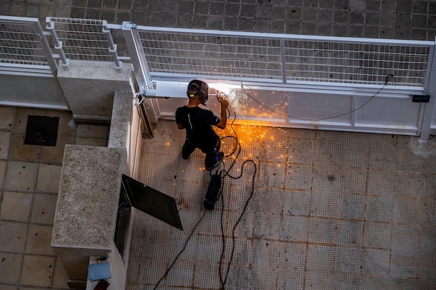 Photo welder at work at a metal gate top view