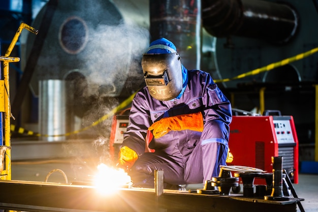 Welder working in an industrial setting manufacturing steel equipment