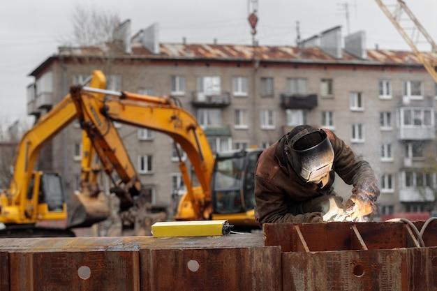 Welder works at the construction of a residential building monolithic construction