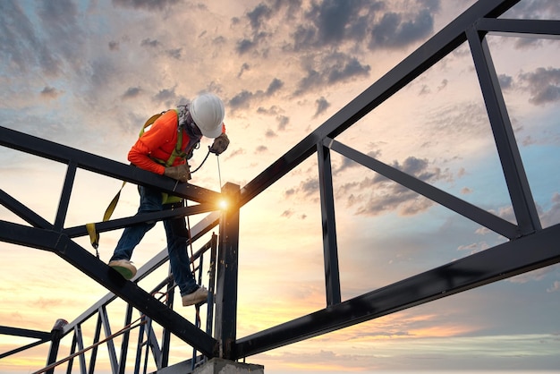 A Welders on risk areas Steel roof truss welders with safety devices to prevent falls from a height in the construction site