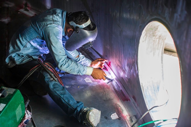 Welding arc argon worker male repaired metal is welding sparks industrial construction tank