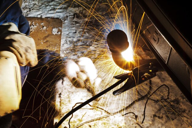 Welding car turnbuckle in snow field at night