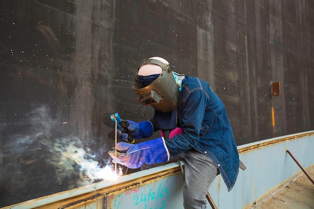 Il metallo del lavoratore maschio della saldatura è parte della diga di schiuma del fumo della costruzione del fascio del carro armato del tetto della piastra del macchinario all'interno degli spazi ristretti