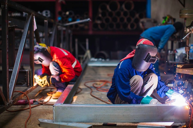 L'acciaio del metallo del lavoratore maschio della saldatura fa parte della struttura della trave