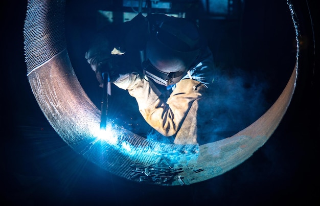 Foto saldatura di strutture in acciaio e scintille luminose nell'industria delle costruzioni in acciaia