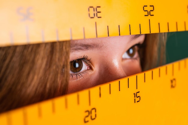 Welke hoek je kijkt kind leerling houd heerser meisje is student terug naar school tiener meisje werk in de klas met wiskundige hulpmiddelen kind leren wiskunde onderwerp modern onderwijs kennis dag