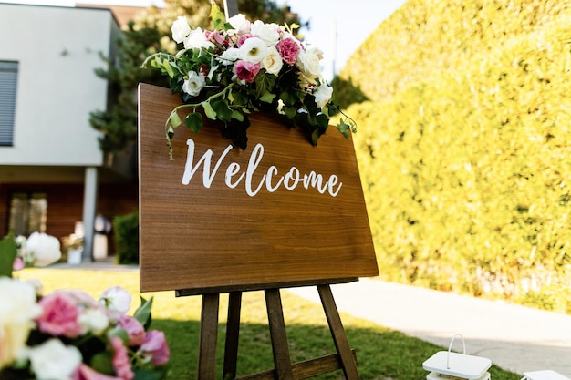 Welkomstbord met bloemstuk bij huwelijksreceptie.