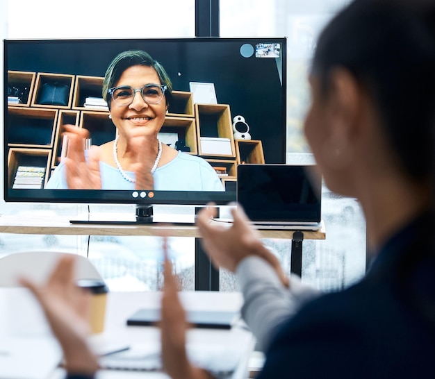 Photo well done everyone on making the deadline in time shot of a group of businesspeople applauding during a video call with a colleague in an office