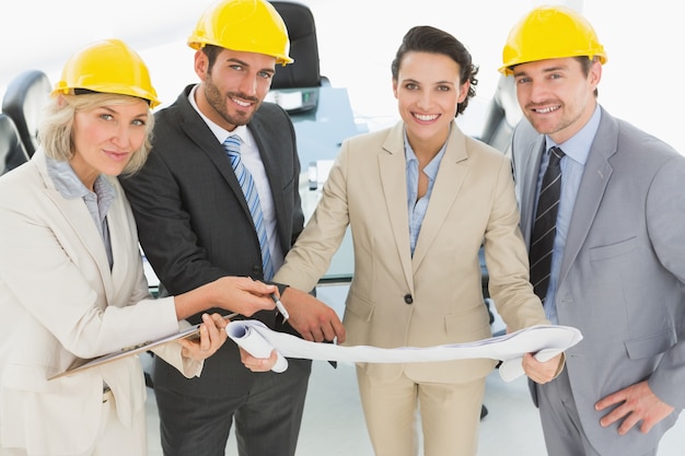 Well dressed architects with hard hats and blueprint