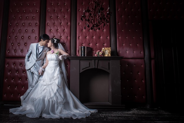 Photo well-dressed couple cuddling against wall