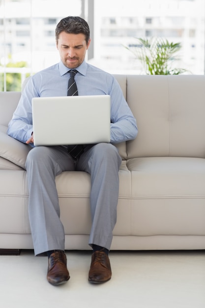 Well dressed man using laptop at home