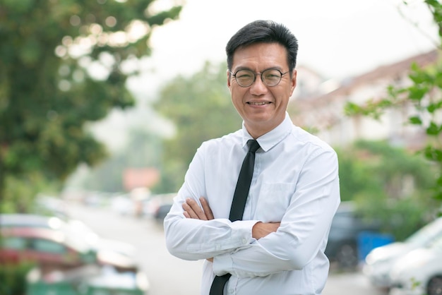 Well dressed mature Asian businessman smiling confidently