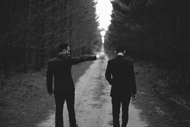 Well-dressed men gesturing while walking on road