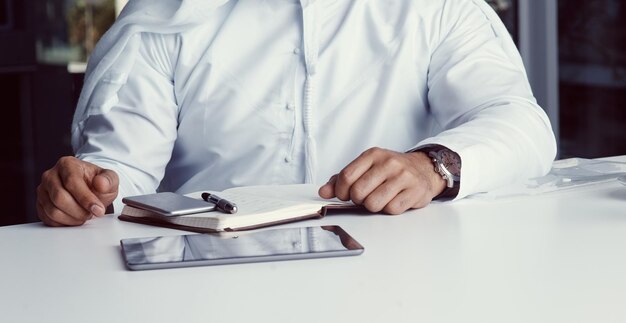 Well equipped to achieve success Cropped shot of an unrecognizable businessman dressed in Islamic traditional clothing working in his office