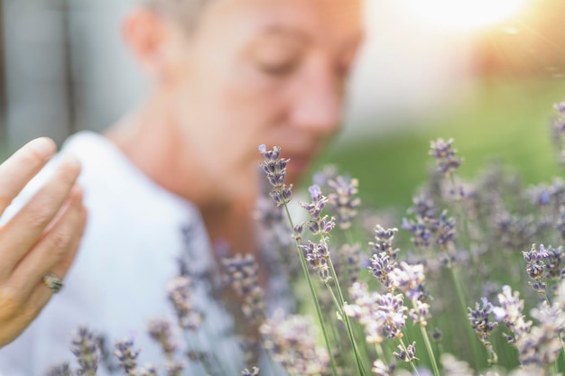 Wellbeing in Nature Woman Enjoying the Scent of Lavender Flowers