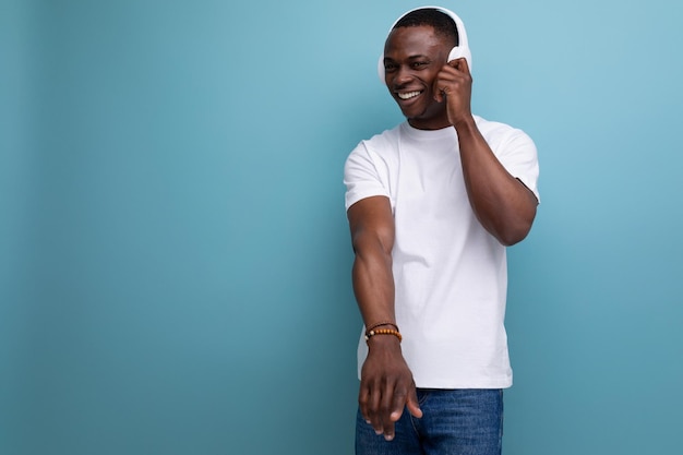 Wellgroomed handsome young african guy dancing to music in headphones