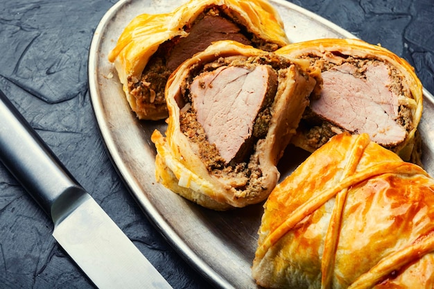 Wellington pork pork tenderloin baked with mushrooms in puff pastry