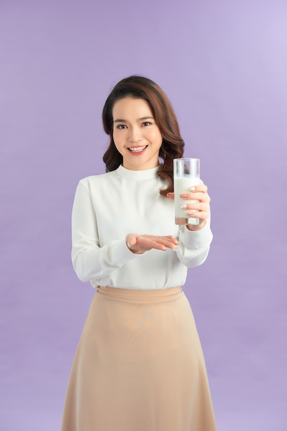 Оздоровительная красотка женщина держит в руке стакан молока