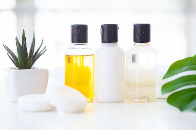 Wellness-producten en cosmetica. Kruiden- en minerale huidverzorging. Potten crème, witte cosmetische flessen. Zonder label. Spa set met zeep en witte handdoek.