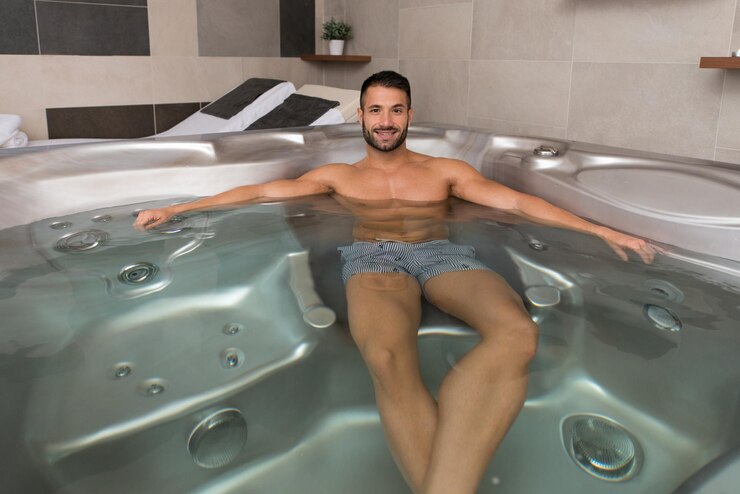 Photo wellness spa  man relaxing in hot tub whirlpool jacuzzi indoors at luxury resort spa retreat  handsome young male model relaxed resting in water near pool on travel vacation holiday
