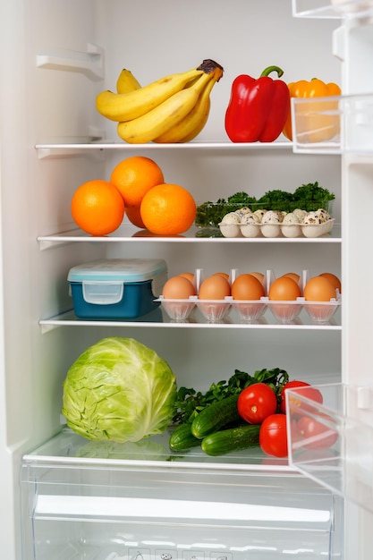 wellstocked refrigerator with fresh produce eggs and other groceries