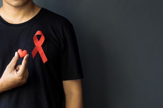 Wereld Aids Dag en Wereld Diabetes Dag met een man met een rood aids-bewustzijnslint op de borst