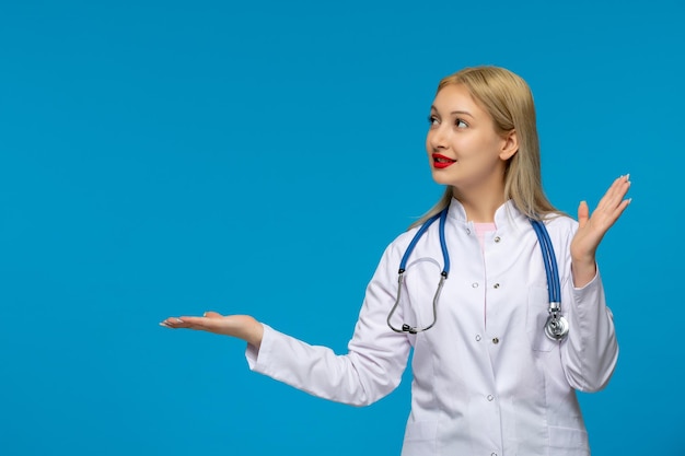 Wereldartsendag gelukkige blonde jonge dokter die naar links kijkt met de stethoscoop in de medische jas