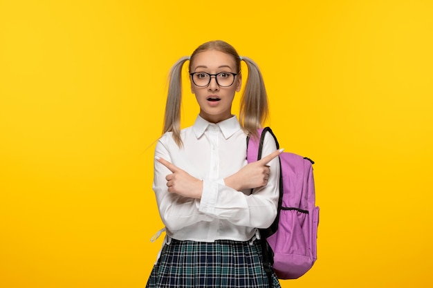Wereldboekendag blond meisje verrast in schooluniform met een gekruiste bril