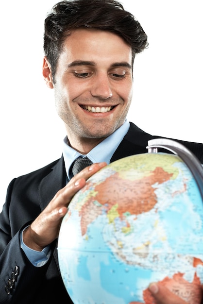 Wereldbol en zakenman met bol aarde en planeet die zich gelukkig voelt over wereldwijde reizen Internationale werknemer en geluk van een werknemer met een geïsoleerde witte achtergrond in een pak met een glimlach