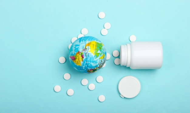 Wereldbol met een fles pillen op een blauw oppervlak