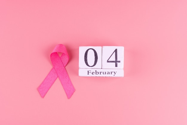 Werelddag voor kanker met kalender van 4 februari en Pink Ribbon ter ondersteuning van mensen die leven en ziek zijn. Gezondheidszorg concept