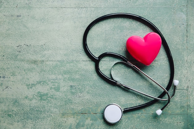 Foto wereldgezondheidsdag, rood hart en stethoscoop op oude houten tafel