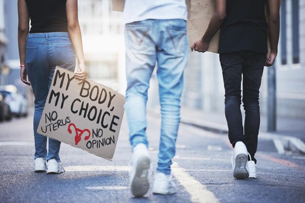 Wereldwijde vrijheid en protestmars voor abortusrechten met bordteken en activisme in een straat in stedelijke stad pro-keuze voor abortus en vrouwelijke empowermenthouding met menigte die vecht voor verandering