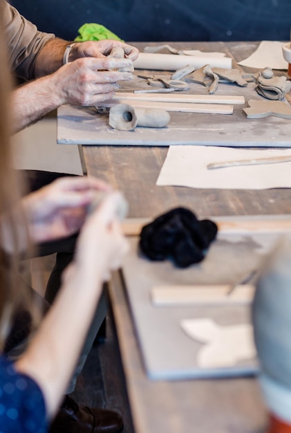 Werk in een pottenbakkerij Een man en een vrouw beeldhouwen uit klei Horizontale fotohanden sluiten omhoog