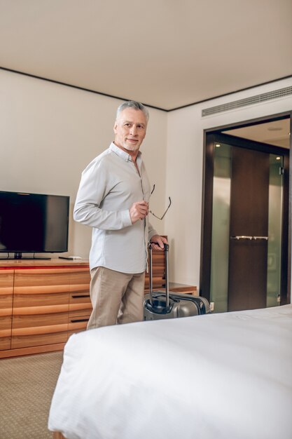 Werk reis. Goed uitziende grijsharige man arriveerde in het hotel