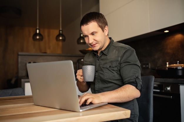 Werk vanuit huis. Man werkt online op laptop binnenshuis