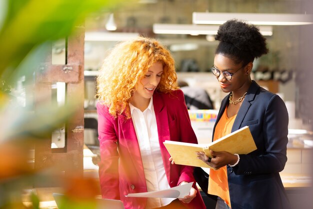 Werkdag plannen. Twee interieurontwerpers lezen wat aantekeningen tijdens het plannen van de werkdag