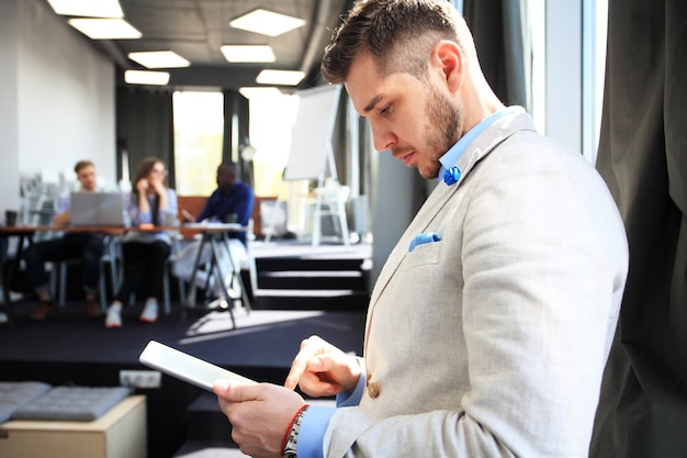 Werken aan nieuwe tablet. Lage hoekmening van zelfverzekerde jonge man aan het werk op digitale tablet