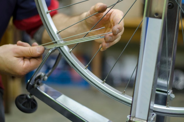 Werken in een fietsenreparatiewerkplaats Fietswielreparatie om spaken in de hand te houden