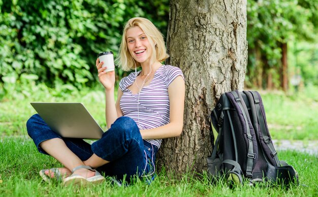 Werken in het zomerpark De natuur is essentieel voor welzijn en het vermogen om productief te zijn Meisjeswerk met laptop in het park Redenen waarom je je werk buiten zou moeten doen Lunchtijd ontspannen of koffiepauze