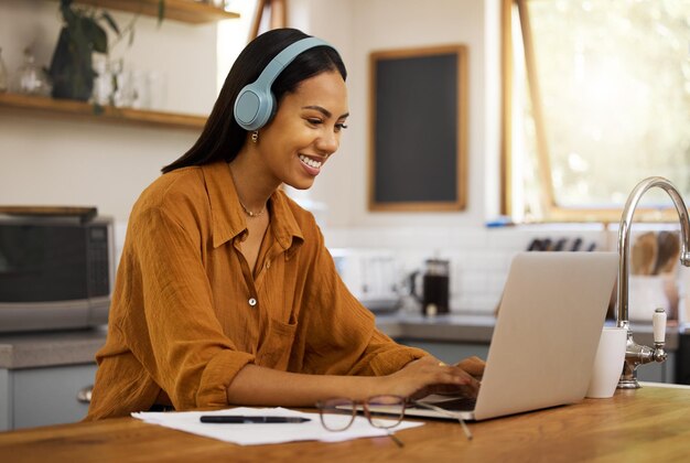 Foto werken op afstand typen en vrouw op laptop gelukkig thuis werken aan projectstrategie en planning in de keuken freelancer bedrijf en meisje met koptelefoon voor muziek online werken en audio streamen