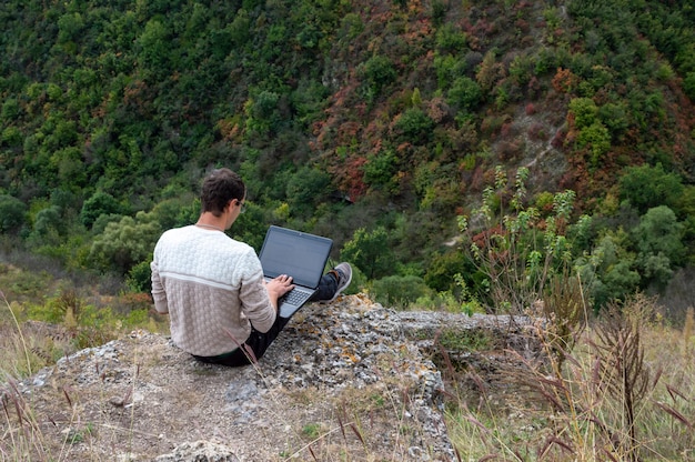 Werken op een laptop in de open lucht in de bergen