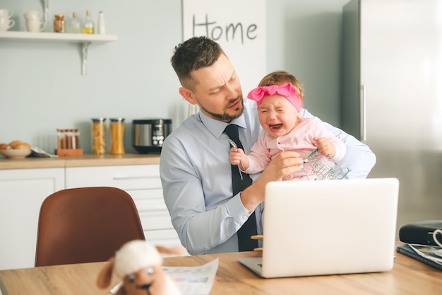 Werkende vader met huilende dochtertje thuis