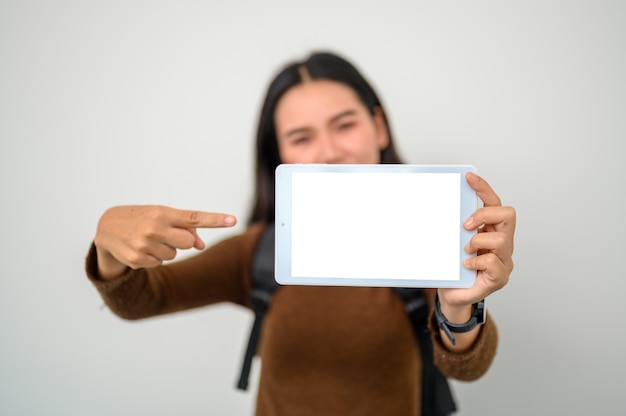 Foto werkende vrouw die houdend een witte het scherm lege tablet bevindt