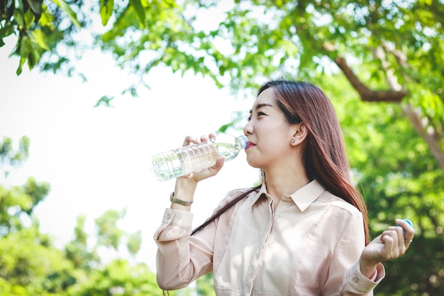 Werkende vrouwen drinken schoon water. Het maakt haar lichaam verfrist.