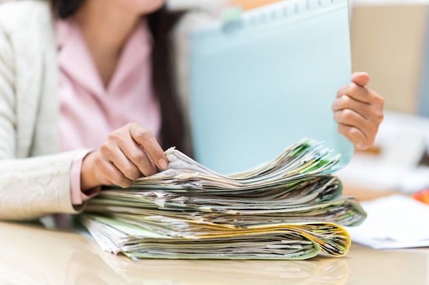 Werkende vrouwen zoeken naar bestanden op hun bureau