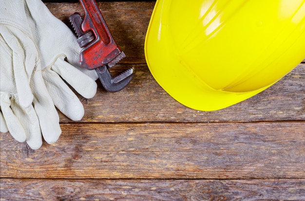 Werkhandschoenen, bouwhelm en bril, gereedschapsuitrusting op houten tafel